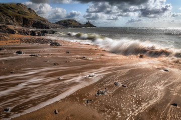 Outgoing tide at Bracelet Bay on the Gower peninsula in Swansea, South Wales, UK