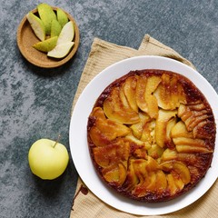 Pear pie on a gray stone. Homemade cake. Gray background. Delicious dessert on a white plate. Food photography. Flan