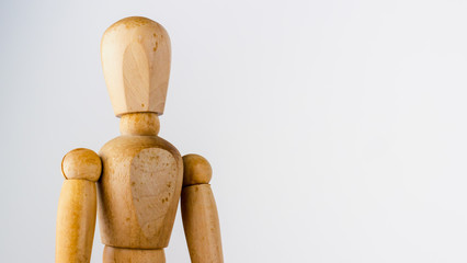 Generic pose of a wooden artist mannequin looking off to the right and isolated against a beautifully graduated grey to white background.