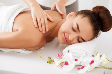 Fototapeta na wymiar Woman enjoying shoulder massage, relaxing with closed eyes