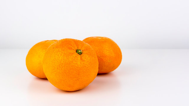 A group of vivid, easy peeler, juicy oranges isolated on a white studio background.