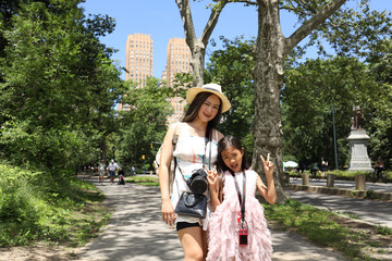 Mothe and daughter visits Central park with Majestic appartments in background