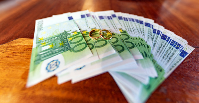 Anelli di matrimonio su banconote da 100 euro, accordi matrimoniali, assegni, costi, spese, avvocati, matrimonialisti