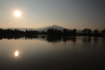 Tramonto sul lago con il sole nel cielo che si riflette sulla acqua