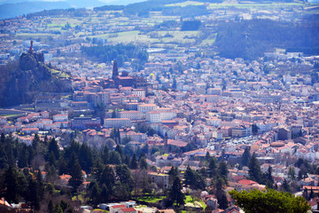Fototapeta premium Aiguilhe, France - March 30th 2019 : view of the city Le Puy-en-Velay, built in a volcanic landscape. You can see the statue of the Virgin, the Church Saint Michel d'Aiguilhe and the cathedral.