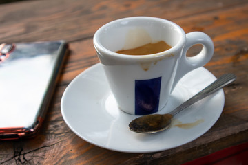 Small cup of espresso coffee on primitive wooden table