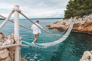 Obraz premium man walking by suspension bridge