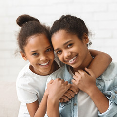 Portrait of two smiling african sisters over white background