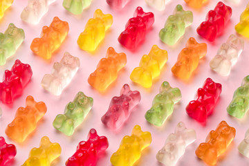 colorful gummy bears pattern over pink background, close-up image