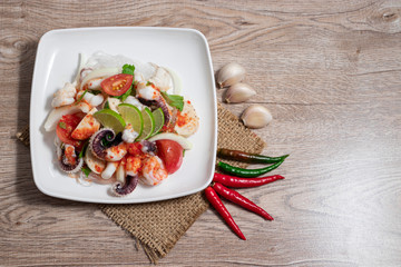 Thai Style spicy seafood salad with noodle isolated on wooden background