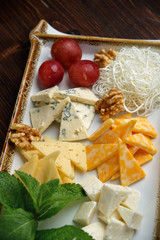Cheese platter on a dark background. Food styling. Restaurant menu