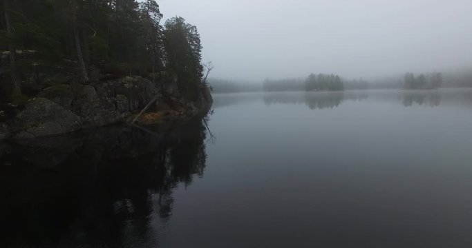 An aerial view of misty lakes and forests of Fiskars in Finland