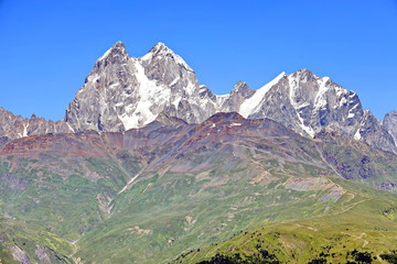 Landscape views of the Caucasus Mountains, river and villages. Peak and river Enguri. Georgia. Summer. 2019