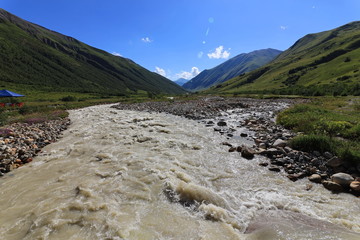 Landscape views of the Caucasus Mountains, river and villages. Peak and river Enguri. Georgia. Summer. 2019