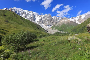 Landscape views of the Caucasus Mountains, river and villages. Peak and river Enguri. Georgia. Summer. 2019
