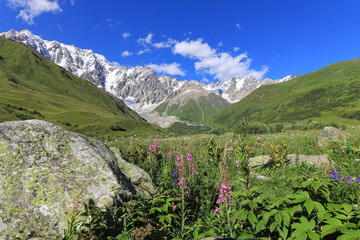 Landscape views of the Caucasus Mountains, river and villages. Peak and river Enguri. Georgia. Summer. 2019