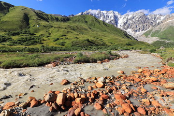 Landscape views of the Caucasus Mountains, river and villages. Peak and river Enguri. Georgia. Summer. 2019