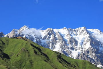 Landscape views of the Caucasus Mountains, river and villages. Peak and river Enguri. Georgia. Summer. 2019