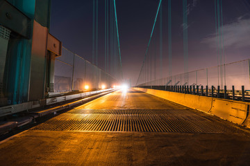 Night view of Vincent Thomas Bridge road grates and on coming headlights in Los Angeles, California.  