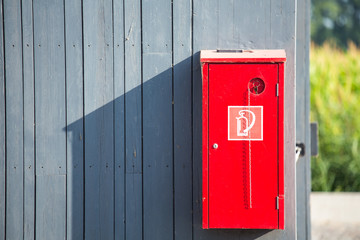 Fire extinguisher on wood wall.