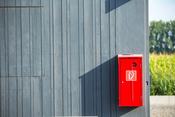 Fire extinguisher on wood wall.