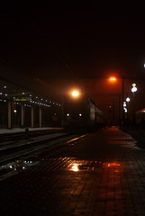 Train on the platform of the railway station at night