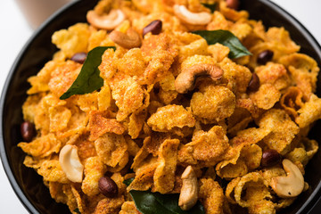 Cornflake Chivda or Corn Chiwda loaded with peanuts and Cashew. Served in a bowl. selective focus
