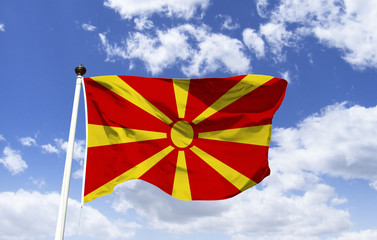 Mockup of Northern Macedonia Flag floating under blue sky. Country located on the Balkan peninsula in southeastern Europe. Motto: Freedom or Death. Capital and most populous city: Skopje