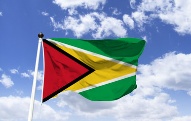 Guyana flag mockup fluttering under blue sky. A country on the North Atlantic coast in South America, the country is culturally linked to the Caribbean region. British colonial architecture. Georgetow