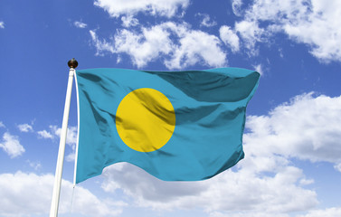 Palau flag mockup floating in the blue sky. Country in Oceania, archipelago with over 500 islands. On the largest of the islands, Babeldaob, the current capital, Ngerulmud. Lake of the living waters.