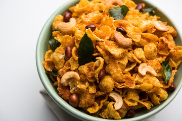 Cornflake Chivda or Corn Chiwda loaded with peanuts and Cashew. Served in a bowl. selective focus