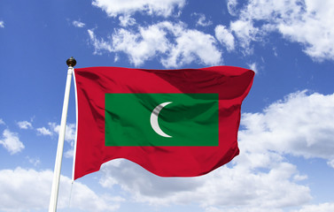 Maldives flag mockup floating under blue sky. Indian Ocean country consisting of 26 ring-shaped atolls, over 1000 coral islands. Male capital. Asia continent. Maafushi Island. Male Atoll