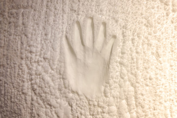 Fototapeta na wymiar Footprint of a human hand on the ice.