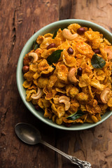 Cornflake Chivda or Corn Chiwda loaded with peanuts and Cashew. Served in a bowl. selective focus