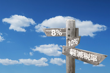 軽減税率8％と10％を指し示す木製看板と青空と雲