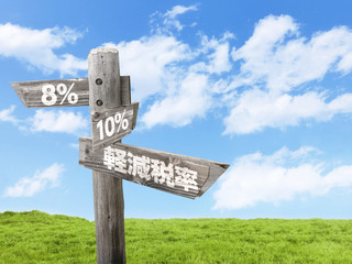 軽減税率8％と10％を指し示す木製看板と青空と草原