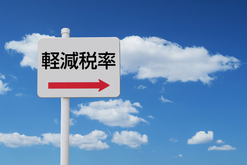 軽減税率を指し示す矢印看板と青空と雲