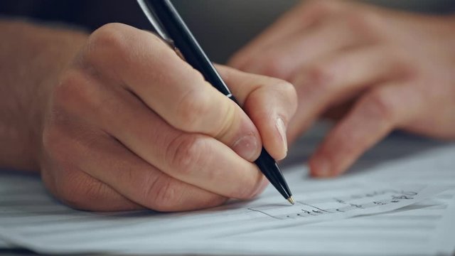 close up view of composer writing notes on music sheet