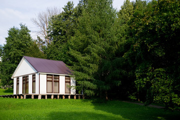 Fototapeta premium small white house with curtained windows stands on a small slope, copy space