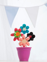 Gominolas dispuestas formando cuatro flores colocadas en un macetero