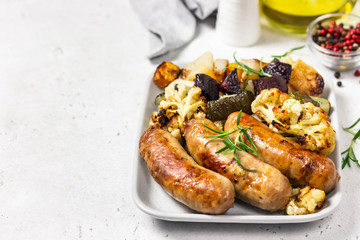 Baked vegetables and sausages. Selective focus, space for text.