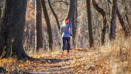 Obraz premium Young fitness woman running in the park