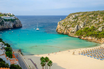 View on on the beach Cala en Porter with white boats, Menorca.