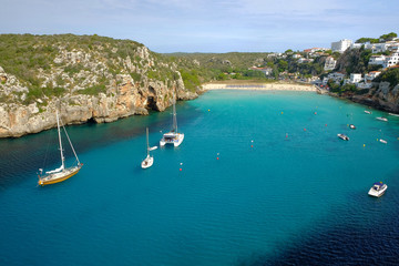 View on on the beach Cala en Porter with white boats, Menorca.