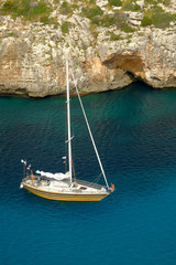 View on white boat on the beach Cala en Porter, Menorca.