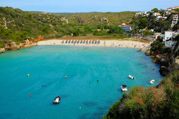 View on on the beach Cala en Porter with white boats, Menorca.