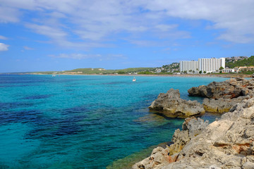 View on the beach Son Bou and white boat on the Balearic Island Menorca, Spain.
