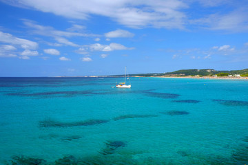 Obraz premium View on the beach Son Bou and white boat on the Balearic Island Menorca, Spain.