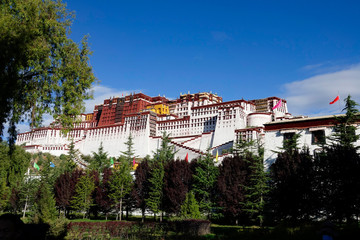 Fototapeta na wymiar Scenic view of ancient Potala Palace atop a Tibetan mountain and a lovely park.