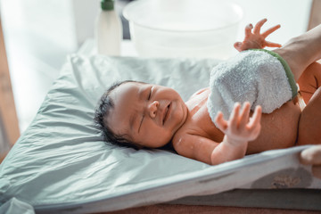 little daughter bath using wet towel with mother at home